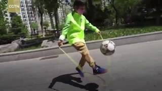 Chinese boy juggles a football while skipping