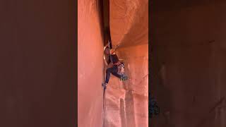 Kaya tırmanışçısı kız vücudunu çatlağa sıkıştırıyor.  Girl rock climber wedges her body into a crack