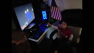 The Heartwarming Moment: Little boy captivated by July 4th fireworks with American flag