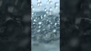 Video of heavy rain drops falling in slow motion, showcasing droplets hitting water