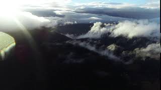 aerial fly over clouds in forest landscape sunset with light rain