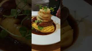 English sausage with mashed potato and union ring, garnished with yummy gravy