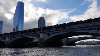 A small boat motoring on the Thames through the centre of London.