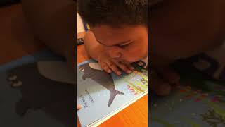 Muna is reading book "Big Shark and Little Shark"