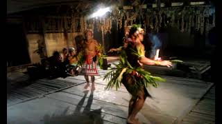 Mentawai tribe men are dancing in a hut in the evening in the jungle. Indonesia. Siberut Island