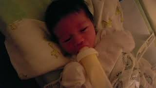 Adorable 1 Week Old Newborn Baby Boy Holding Bottle Feeding On His Moms Milk