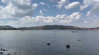 A lake with boats and rocks in the water