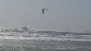 kite surfers on huntington beach on a stormy day