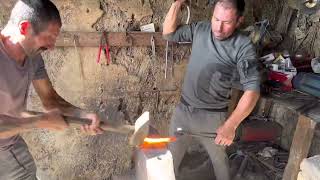 Blacksmith forging and mounting horse shoes