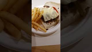 Philly cheese steak on a sub with cheese, green and red peppers serve with fries.