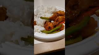 Manchuria chicken with red and green peppers serve with white rice.