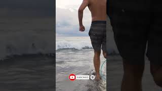 Handheld Tracking Shot Following Surfer Running Into Sea